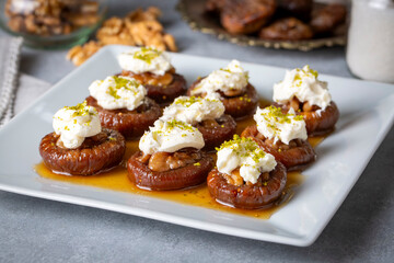Stuffed dry fig dessert, cooked with syrup, traditional, pistachio and kaymak (Turkish name; kaymakli incir tatlisi )