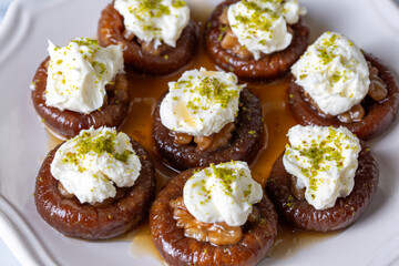 Stuffed dry fig dessert, cooked with syrup, traditional, pistachio and kaymak (Turkish name; kaymakli incir tatlisi )