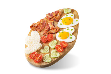 Fresh breakfast with fried eggs, fried bacon slices, bread slices and vegetables in the form of heart for Valentine's day holiday on a white isolated background