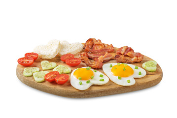 Fresh breakfast with fried eggs, fried bacon slices, bread slices and vegetables in the form of heart for Valentine's day holiday on a white isolated background