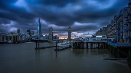 london skyline with tower bridge during sunrise with stormy sky, england