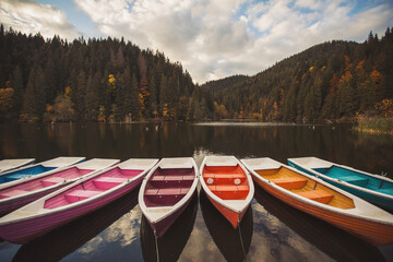 Boats on majestic mountain lake Lacul Rosu or Red Lake or Killer Lake. Splendid autumn scene of...