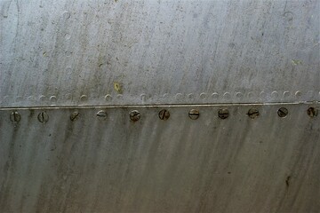 Fuselage metal plate joint. Fragment of an old airplane fuselage.