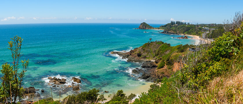 Australian coast, view from a cliff of the blue ocean and a rocky shore with a sandy beach. Small bays with volcanic rock, sunny day. © Castigatio