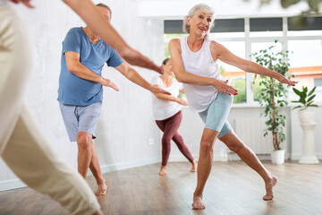 Senior woman attending group choreography class, learning modern dynamic dances.