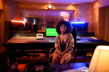 Portrait of a young musician sitting in a recording studio.