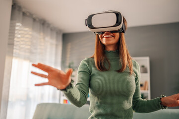 A happy woman is using vr headset at home.