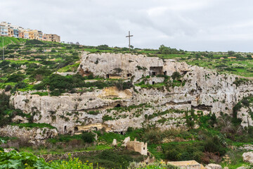 Fototapeta na wymiar Mellieħa, Malta - December 24th 2022: The Mellieha Cave dwellings built into the cliff overlooked the valley.