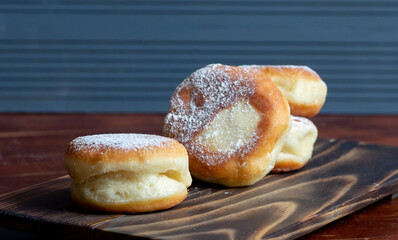 Berliner doughnuts with strawberry jam close-up on a wooden stand