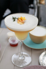 Lady Cocktail or mocktails in elegant glass surrounded by bakery and coffee on gray table. Summer drink in crystal glass.