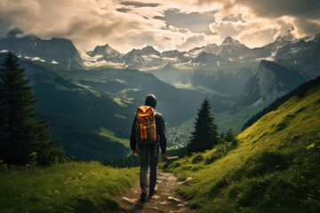 Fototapeta premium A lone tourist with a backpack walks along a mountain path with stunning views of the Alpine peaks and valleys
