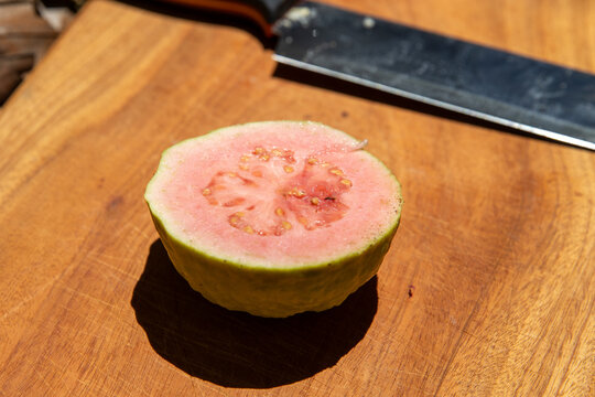 Sliced Pink Guava on Wooden Cutting Board &ndash; Fresh Tropical Fruit Close-Up