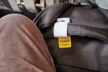 Cabin bag in front of seat on economy class flight