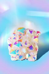 A Close Up of a Angel Aura Quartz Natural Gemstone on a Pastel Blue Background