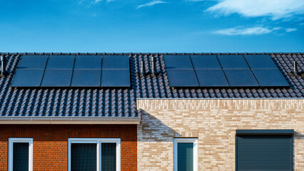 Fototapeta premium Newly built houses with black solar panels attached to the roof , Photovoltaic panels on the roof, sun energy green energy transition in the Netherlands