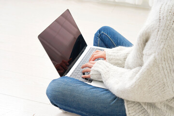 リビングでノートパソコンを使う女性　顔無し