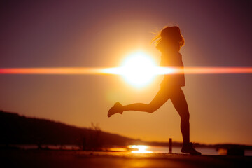 Happy Silhouette of a Woman Jumping with Energy and Joy. Cheerful carefree healthy woman feeling...