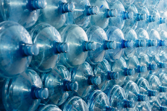 Water gallon pile stock. Plastic PET drinking bottle in drink water plant factory store in clean hygiene storage warehouse.