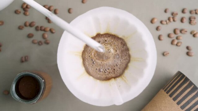 Closeup of pour over filter coffee on top view with coffee brewing equipment on background.