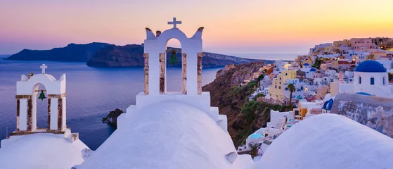 Fototapeten White churches an blue domes by the ocean of Oia Santorini Greece, traditional Greek village © Tudosa