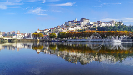 Water reflection of a hilly riverside old town on autumn morning Coimbra Portugal - obrazy, fototapety, plakaty