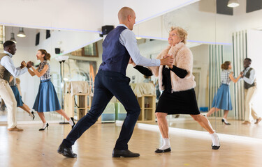 Mature woman dancing swing with young man