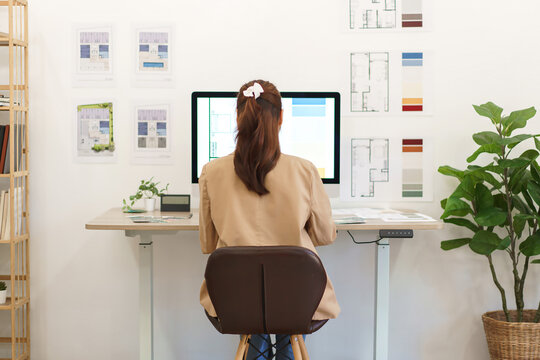 Architectural concept, Behind view female architect working about design house interior on computer