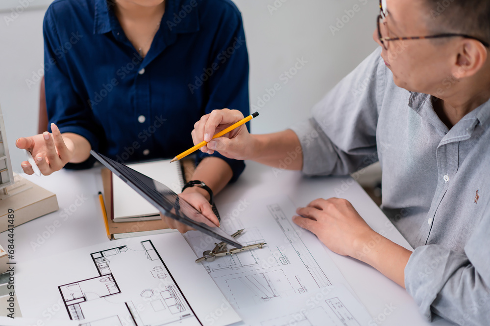 Aufkleber two architects checking blueprint on tablet and analyzing about construction of building project