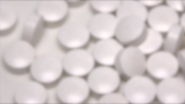 ぼかし背景素材: 押し寄せてくる大量の白色錠剤の薬、サプリメントのクローズアップ  4K