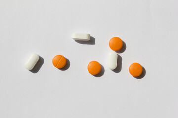 white and orange color pills on a white background