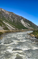 The swing bridge over the flooded Hooker river in the valley at the base of Aoraki Mt Cook