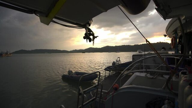 Diving platform of the Oktavia liveaboard scuba boat in the port of Khao Lak, western Thailand. Sunset, with a storm rolling in overnight.