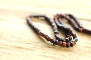 Muslim prayer rosary beads isolated on wooden background.