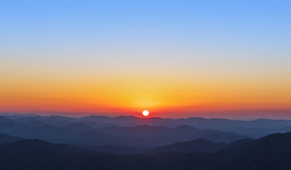 A view of the sun setting over the mountains. sunset