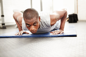 Black man, gym and push up at a wellness club with exercise, fitness and workout with strength. Power, floor and African male athlete with training strong arms on the ground for health and sport