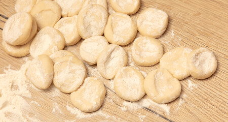 Dough for dumplings on a wooden table