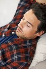 Relax, sleeping and man on sofa in home for afternoon nap, resting and calm in living room. Asleep, eyes closed and face closeup of tired person on couch lying for fatigue, comfortable and wellness