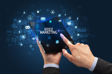 Businessman holding a foldable smartphone, social media concept