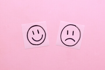 Happy and Sad Faces on Two Pieces of Memo Paper.