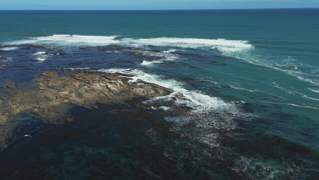 Slow drift above rocky Atlantic coastline, kelp forests sway in gentle waves