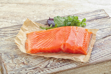 Raw salmon fillet over board