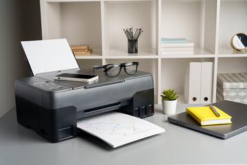 New modern printer and laptop in the office on table