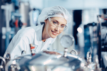 Women worker in drinking water plant clean hygiene uniform monitor control pressure gauge water...