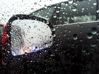 Water droplets on car's window in rainy season struck in traffic jam