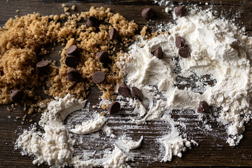 close-up of sugar, flour, and chocolate chips on a wooden surface