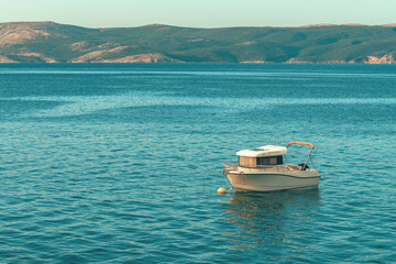 Fishing boat floating on water close to the Adriatic sea shoreline in Kvarner bay