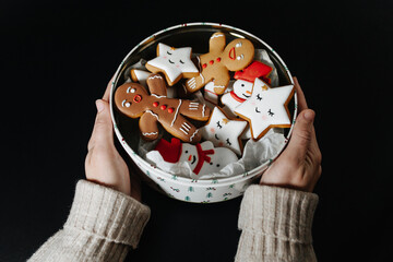 The can with Christmas cookies in the hands