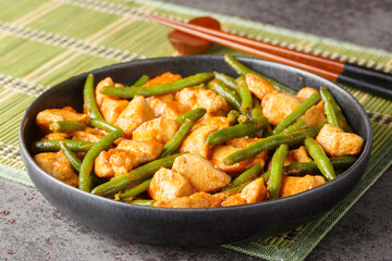 Pad Prik King is Thai red curry stir-fried green beans and Chicken closeup on the plate on the table. Horizontal