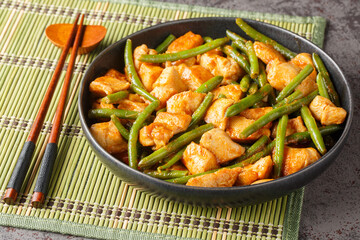 Phat phrik khing or pad prik king is a Thai stir-fried red curry with chicken and long beans...