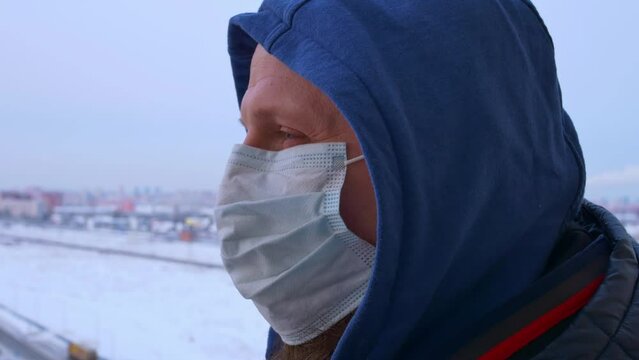 Man in sterile mask and hood stands on street, symbolizing outbreak of infection. Video captures essence of infection outbreak, showcasing vigilant individual during infection surge.